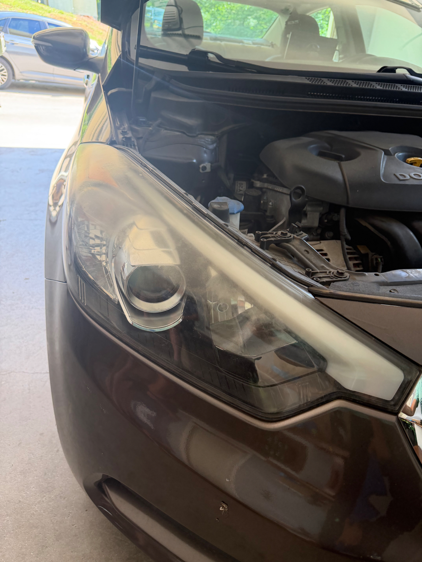 Oxidized headlight before restoration on a brown crossover.