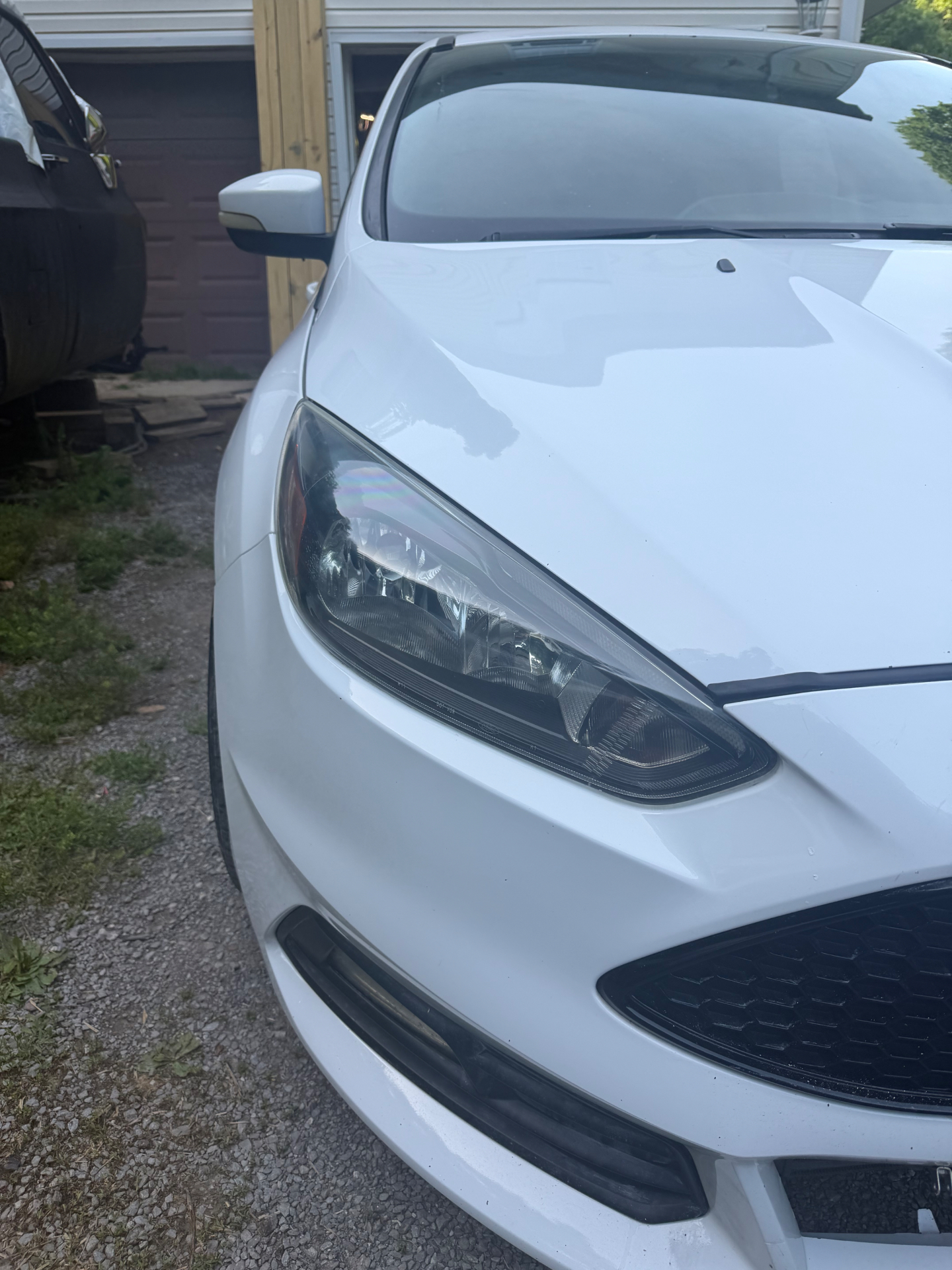 Clearer headlight after restoration on a white hatchback.